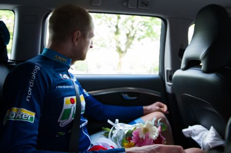 PÅ VEI HJEM: Reidar Borgersen tenker gjennom dagen, etter premieseremonien. I fanget har han blomster, en plakett og den røde trøyen han brukte på podiet.